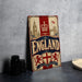 A vintage-style metal sign with the word "ENGLAND" prominently displayed, featuring images of iconic landmarks and symbols associated with the United Kingdom.