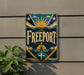 a sign with the word "Freeport" on it, mounted on a wall.