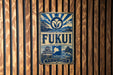 a vintage-style sign with a blue and white color scheme, mounted on a wooden wall.
