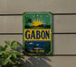 a vintage-style sign with a tropical landscape and palm trees, mounted on a wall.