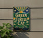 A vintage-style sign for "Green Turtle Cay" is displayed on a wall, featuring a turtle and palm trees.
