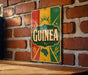 A vintage-style sign with the word "GUINNESS" prominently displayed, mounted on a brick wall.