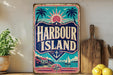 A vintage-style metal sign with the text "Harbour Island" displayed prominently, featuring a tropical beach scene with palm trees, a sun, and a sailboat.