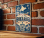 A vintage-style metal sign with the word "Hokkaio" prominently displayed, featuring a star and snowflake design, mounted on a brick wall.