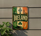 a vintage-style sign with the word "IRELAND" prominently displayed, surrounded by various Irish symbols and landmarks.