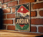 A vintage-style metal sign with the word "JORDAN" prominently displayed, featuring a brick wall and a star in the background.