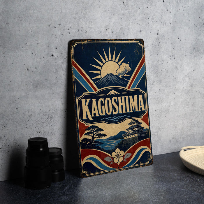 A vintage-style metal sign with the word "KAGOSHIMA" prominently displayed, featuring a sun and mountain landscape design.