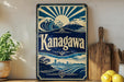 A vintage-style metal sign with a blue and white design, featuring a wave, mountain, and city skyline, along with the text "Kanagawa". The sign is displayed on a shelf next to a wooden cutting board and some potted plants.