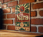 A vintage-style metal sign with the word "Nara" prominently displayed, featuring a deer and a temple in the background.