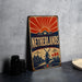 A vintage-style metal sign with the text "Netherlands" prominently displayed, featuring a sunburst design and illustrations of tulips and windmills.