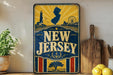 A vintage-style sign for New Jersey featuring a lighthouse, ferris wheel, and other nautical elements, along with the text "NEW JERSEY" prominently displayed.