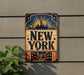 A vintage-style metal sign with the text "NEW YORK" prominently displayed, featuring a depiction of the Statue of Liberty and a sunburst design.