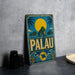 A vintage-style metal sign with a tropical island landscape and a large yellow sun in the sky, featuring the word "PALAU" prominently displayed.