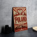 A vintage-style metal sign with the word "POLAND" prominently displayed, featuring a red and white color scheme and an illustration of a castle and mountains.