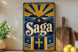 a vintage-style sign with the word "Saga" prominently displayed, surrounded by a sunburst design and other decorative elements. The sign is placed on a shelf next to a wooden cutting board and a potted plant, creating a rustic and charming atmosphere.