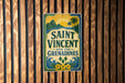 A vintage-style sign for Saint Vincent and the Grenadines, featuring a tropical landscape with palm trees and a sun.