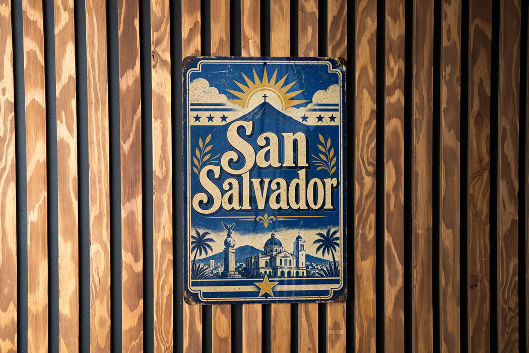 A vintage-style sign for San Salvador, featuring a sun and palm trees, is displayed on a wooden wall.
