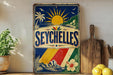 a vintage-style sign with a tropical design, including palm trees, a sun, and a hibiscus flower, along with the word "SEYCHELLES" prominently displayed.