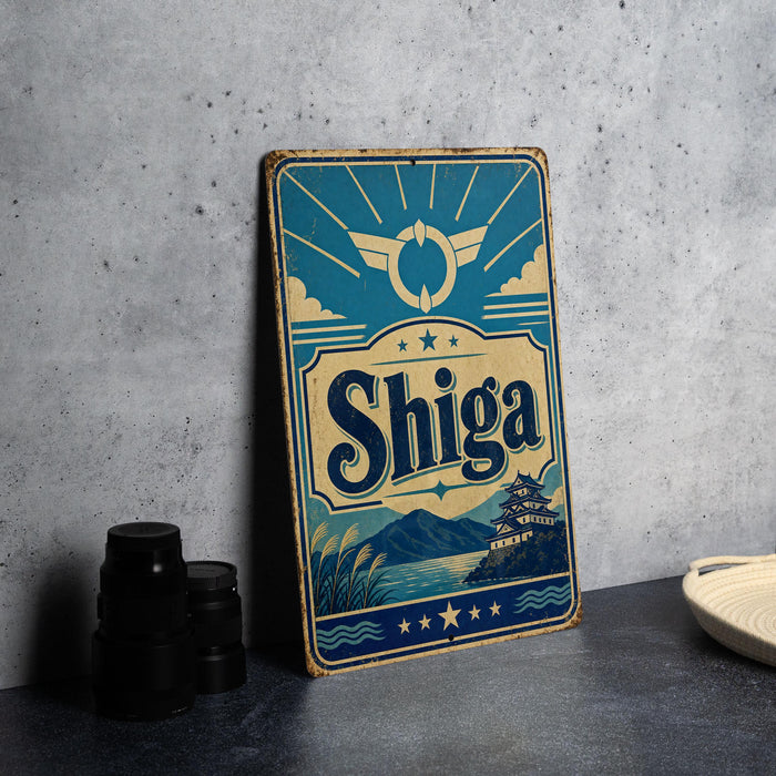 A vintage-style sign for Shiga, a Japanese beer brand, is displayed on a table next to some black camera lenses.