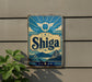 a sign with the word "Shiga" on it, which is mounted on a wall.