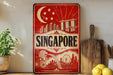 A vintage-style sign featuring the city of Singapore, with a crescent moon and stars, a mermaid, and a ferris wheel, along with the word "SINGAPORE" prominently displayed.