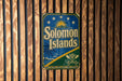 A vintage-style sign for the Solomon Islands is displayed on a wooden wall.
