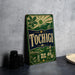 A vintage-style metal sign with the word "Tochigi" prominently displayed, featuring a sun, mountains, and other scenic elements.