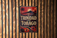 A vintage-style sign with the text "TRINIDAD AND TOBAGO" displayed on a wooden wall.