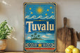 A vintage-style sign for Tuvalu, featuring a tropical island landscape with palm trees and a sun, is displayed on a shelf next to a wooden cutting board and some lemons.