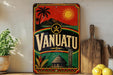 A vintage-style sign for Vanuatu, featuring palm trees, mountains, and a sun, is displayed on a shelf next to a wooden cutting board and some lemons.