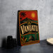A vintage metal sign with the word "VANUATU" prominently displayed, featuring a tropical landscape with palm trees, mountains, and a sun.
