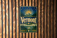 A vintage Vermont beer sign is displayed on a wooden wall.