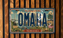 A vintage license plate from Nebraska featuring an illustration of the state's landmarks and scenery.