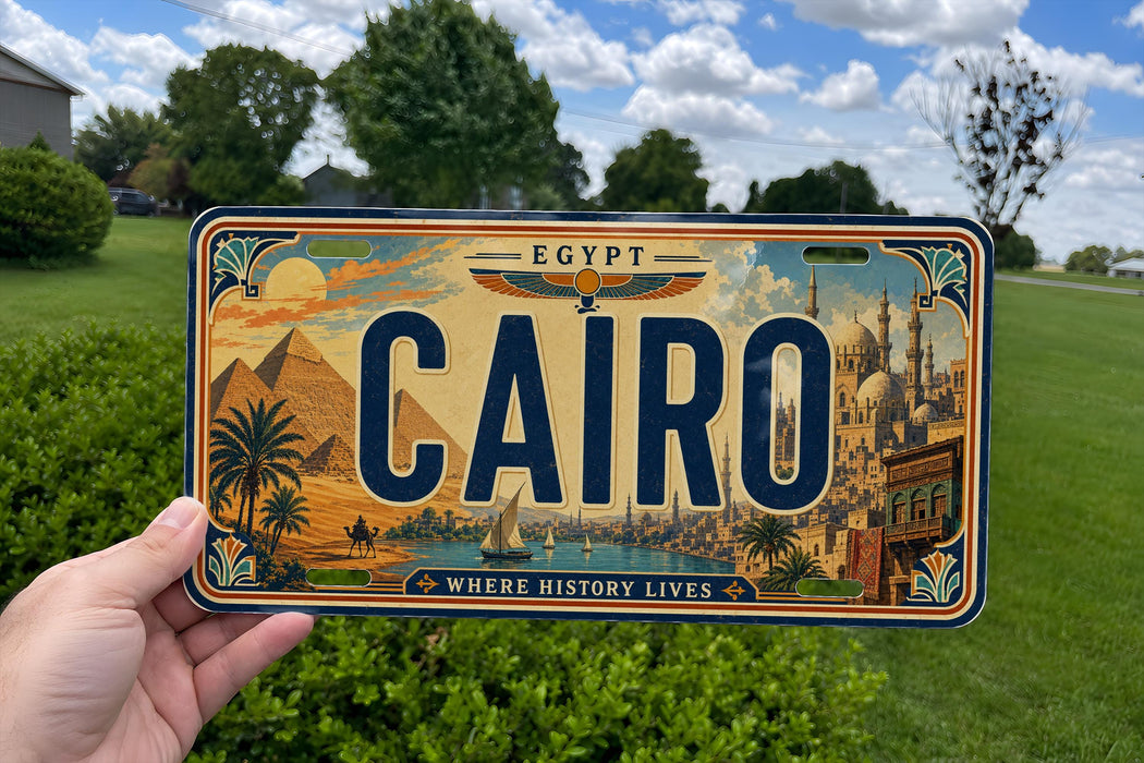 A person is holding a license plate with the word "CAIRO" prominently displayed on it.