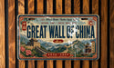 A vintage-style license plate with the text "Great Wall of China" and an illustration of the iconic wall of China.