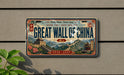 A vintage-style license plate with the text "GREAT WALL OF CHINA" and an illustration of the Great Wall of China.