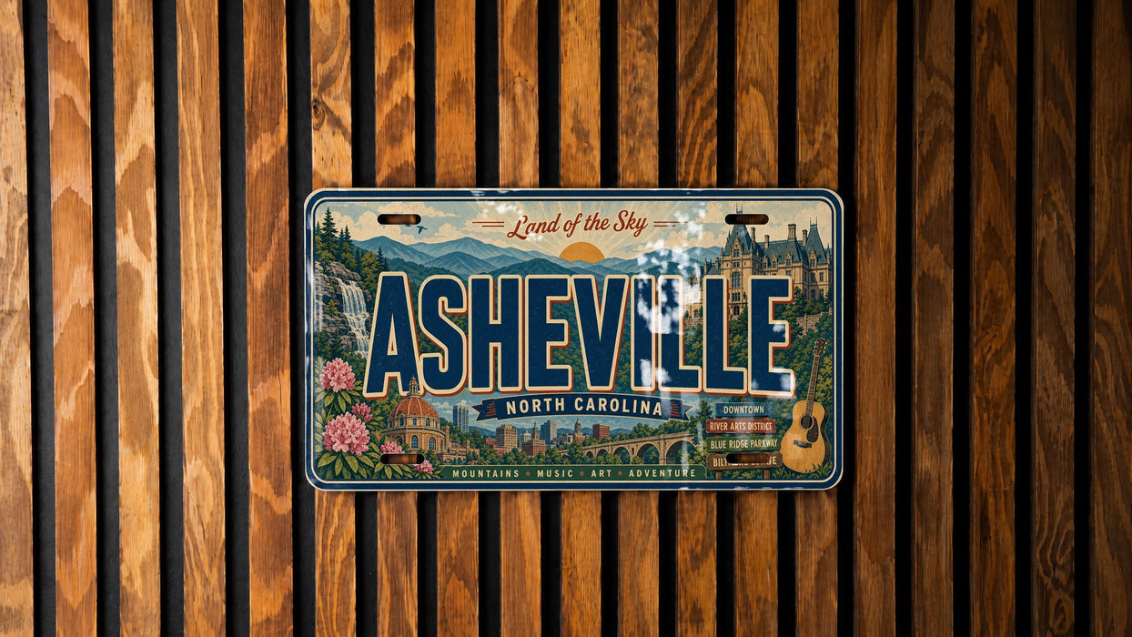 A vintage license plate from North Carolina, featuring the city of Asheville, is displayed against a wooden background.
