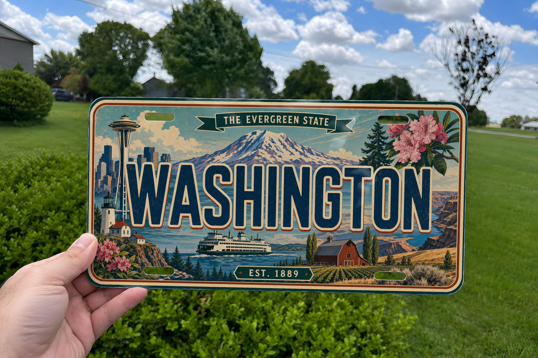 A person is holding a Washington state license plate with a scenic mountain and cityscape design.