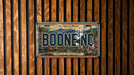 A vintage license plate from Boone, North Carolina, with a scenic mountain landscape and the text "Life is Better in the Mountains" displayed on it.