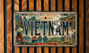 a vintage license plate from Vietnam with a scenic illustration of the country's landscape, including mountains, rivers, and traditional Vietnamese architecture.