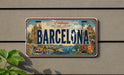 A vintage license plate from Barcelona, Spain, featuring the city's iconic landmarks and a colorful, decorative design.