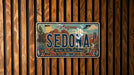 A vintage Arizona license plate with a scenic illustration of Sedona, a famous desert city in Arizona.