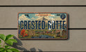 A vintage-style license plate for Colorado, featuring the name "Crested Butte" and a mountain landscape.
