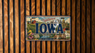 A vintage Iowa license plate with a colorful illustration of the state's landmarks and scenery.