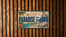 A license plate from Paradise Island, Bahamas, with a tropical beach scene and palm trees.