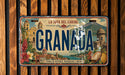 A vintage license plate from Granada, featuring an illustration of the city's landmarks and natural scenery.