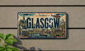 A vintage license plate from Scotland that features the city of Glasgow, with various landmarks and scenery depicted on the plate.