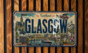 A vintage license plate from Scotland that features an illustration of the city of Glasgow.