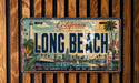 A vintage California license plate with the text "California Coastal Living - Urban Spirit" and "Long Beach" printed on it, featuring an illustration of a coastal cityscape with a lighthouse, palm trees, and a ship.