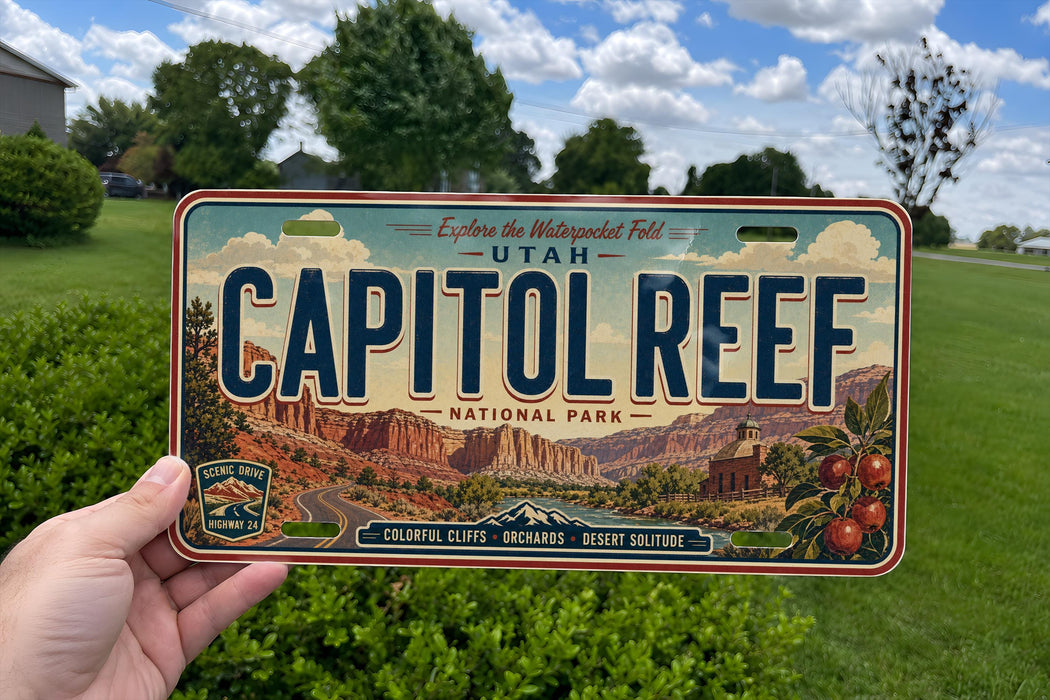 A person is holding a license plate with the text "CAPITOL REEF" and an illustration of a desert landscape.